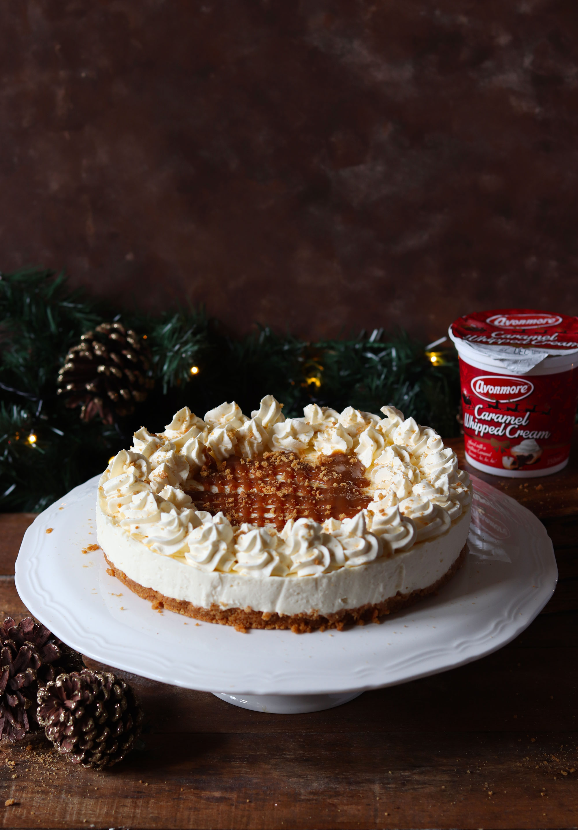 NO BAKE CARAMEL CHEESECAKE WITH A GINGER NUT CRUST AND AVONMORE CARAMEL WHIPPED CREAM FROSTING DRIZZLED WITH CARAMEL SAUCE